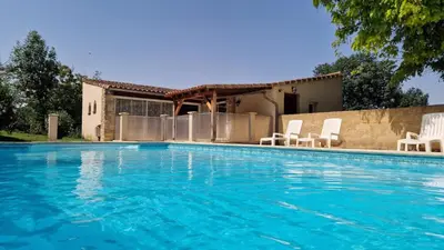 a swimming pool with chairs and a house at Gite complex near Mirepoix in the Pyrenees in Limbrassac
