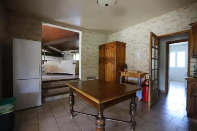 a kitchen with a table and a refrigerator and a bed at Gite complex near Mirepoix in the Pyrenees in Limbrassac