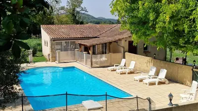 a swimming pool with chairs and a house at Gite complex near Mirepoix in the Pyrenees in Limbrassac