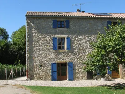 an old stone house with blue shutters on it at Gite complex near Mirepoix in the Pyrenees in Limbrassac