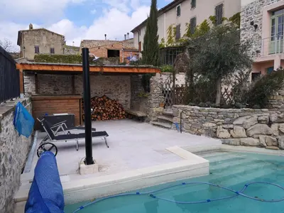a pool with a bench next to a building at L'Ours des Corbières - Chambres d'hôtes in Serviès-en-Val