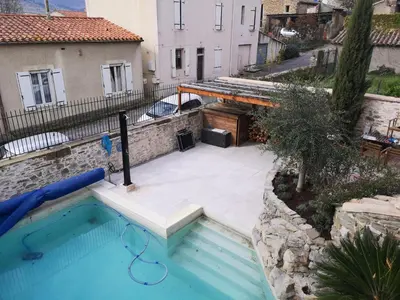 a swimming pool in front of a building at L'Ours des Corbières - Chambres d'hôtes in Serviès-en-Val