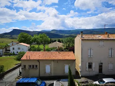 a view of two houses with mountains in the background at L'Ours des Corbières - Chambres d'hôtes in Serviès-en-Val