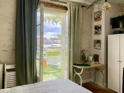 a bedroom with a door open to a balcony at Le Grand Bassin in Castelnaudary