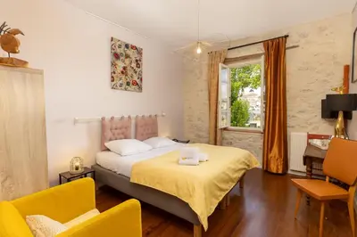 a bedroom with a bed and two chairs and a window at Le Grand Bassin in Castelnaudary