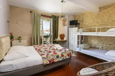 a bedroom with two bunk beds and a balcony at Le Grand Bassin in Castelnaudary