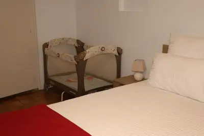 a bedroom with a bed and a chair next to it at Studio au Coeur du Village avec terrasse et parking proche de Pamiers in Verniolle