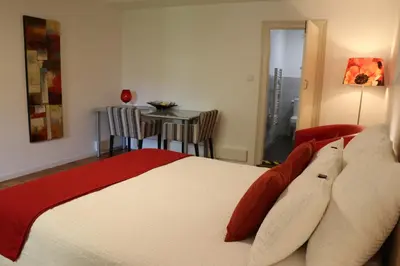 a bedroom with a bed and a table with chairs at Studio au Coeur du Village avec terrasse et parking proche de Pamiers in Verniolle