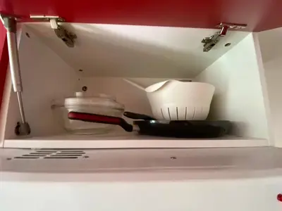 a shelf in a kitchen with some utensils at Studio au Coeur du Village avec terrasse et parking proche de Pamiers in Verniolle