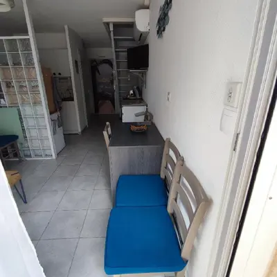 a room with a table and a blue bench at Maison près de la plage in Port-la-Nouvelle