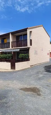 a building with a parking lot in front of it at Maison près de la plage in Port-la-Nouvelle