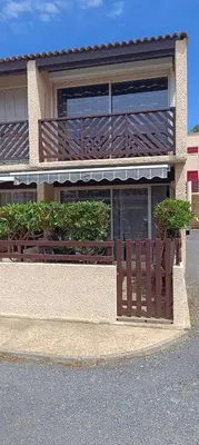 a building with a wooden fence in front of it at Maison près de la plage in Port-la-Nouvelle