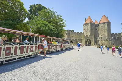 a train with people riding on it in front of a castle at FranceComfort - L'Espinet in Quillan