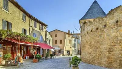 a street in an old town with a brick wall at FranceComfort - L'Espinet in Quillan