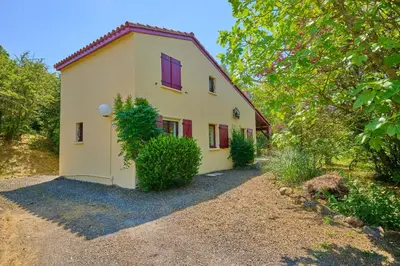a small white house with red windows and trees at FranceComfort - L'Espinet in Quillan