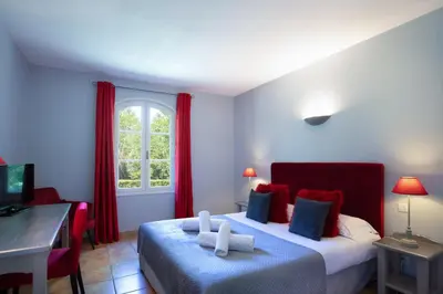 a hotel room with two beds and a desk and a computer at Hôtel La Bastide Saint Martin in Carcassonne