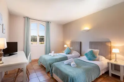 three bottles of essential oils and a book on a shelf at Hôtel La Bastide Saint Martin in Carcassonne