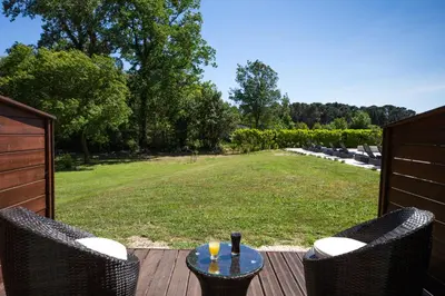 a patio with two chairs and a table on a deck at Hôtel La Bastide Saint Martin in Carcassonne