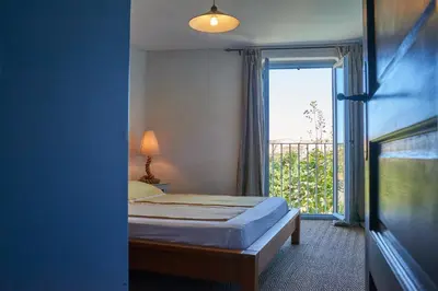 a bedroom with a bed and a large window at Jardin de Palme in Lapalme