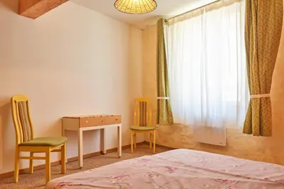 a bedroom with a bed and a desk and a window at Jardin de Palme in Lapalme