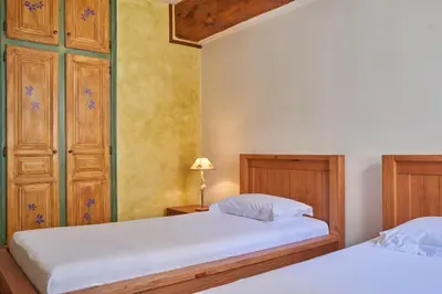 a bedroom with two beds and a lamp on a table at Jardin de Palme in Lapalme