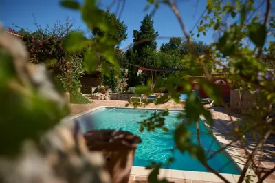 a swimming pool in the yard of a house at Jardin de Palme in Lapalme