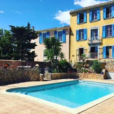 a swimming pool in front of a building at Jardin de Palme in Lapalme
