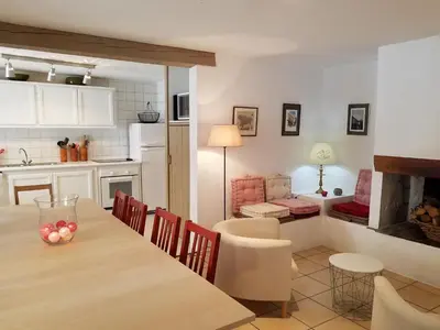 a kitchen and living room with a table and chairs at Château La Villatade in Sallèles-Cabardès