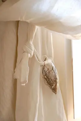 a white bed with a gold object on top of it at La Maison Vieille Maison d'Hôtes & Gîtes in Carcassonne
