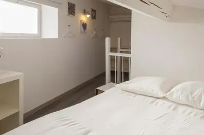 a white bed in a room with a window at La Maison Vieille Maison d'Hôtes & Gîtes in Carcassonne