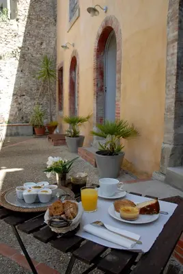 a table with breakfast foods on it on a patio at La Maison Vieille Maison d'Hôtes & Gîtes in Carcassonne