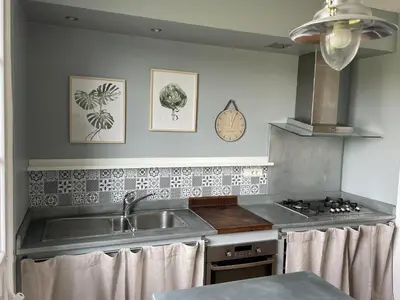 a kitchen with a sink and a stove at Le Gîte de la Bade in Villegailhenc