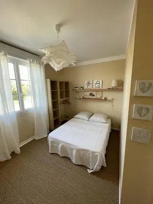 a bedroom with a white bed and a window at Le Gîte de la Bade in Villegailhenc