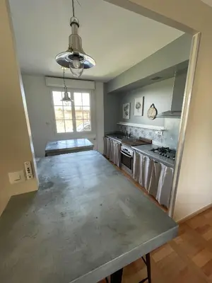 an empty kitchen with stainless steel appliances and a window at Le Gîte de la Bade in Villegailhenc