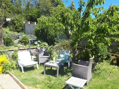 a group of chairs and a table in a yard at Chez Charlotte et Michel in Brassac