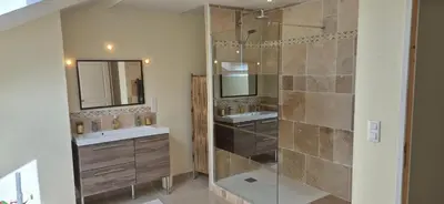a bathroom with two sinks and a shower at Chez Charlotte et Michel in Brassac