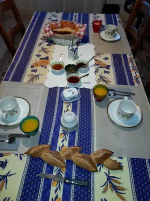 a table with plates and bowls of food on it at Chez Charlotte et Michel in Brassac