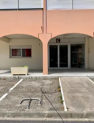 a building with two arches on the side of it at Studio Les Régates avec loggia et parking gratuit Plage du Grazel Gruissan in Gruissan