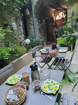 a table with plates and utensils on a patio at Chambres d hôtes Le clos des vins d anges in Saint-Pierre-des-Champs