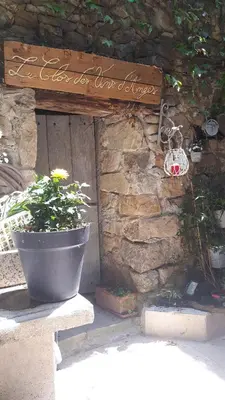 a pot sitting next to a stone wall with a sign at Chambres d hôtes Le clos des vins d anges in Saint-Pierre-des-Champs