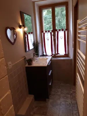a bathroom with a sink and a shower with windows at Chambres d hôtes Le clos des vins d anges in Saint-Pierre-des-Champs
