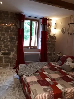 a bedroom with a bed with red curtains and a window at Chambres d hôtes Le clos des vins d anges in Saint-Pierre-des-Champs