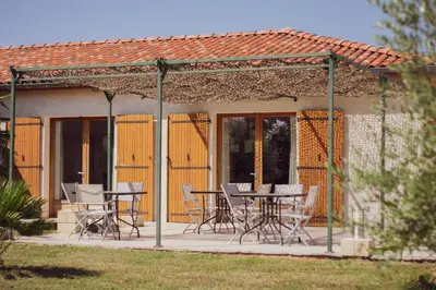 a gazebo with chairs and a table on a patio at Chambre d'hôtes Lempery in Puéchoursi