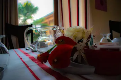 a table with flowers on a red and white table cloth at Chambre d'hôtes Lempery in Puéchoursi