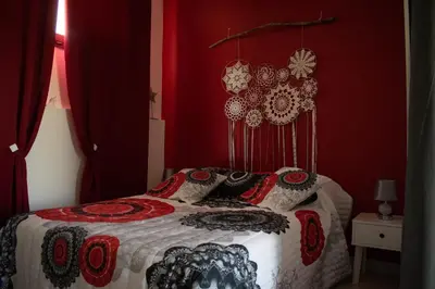 a bedroom with a bed with red walls at Chambre d'hôtes Lempery in Puéchoursi