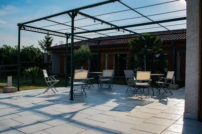 a patio with chairs and a table under a pergola at Chambre d'hôtes Lempery in Puéchoursi