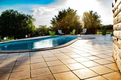 a swimming pool in a yard with chairs around it at Chambre d'hôtes Lempery in Puéchoursi