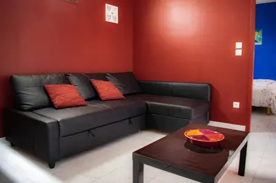 a living room with a black couch and a table at Gîte Lempery in Puéchoursi
