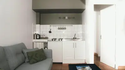 a living room with a couch and a kitchen at Château Canet in Rustiques