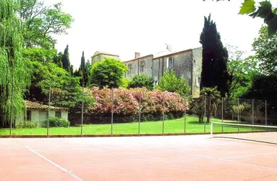 a house with a yard with trees and flowers at Hôtel Château de Cavanac in Carcassonne